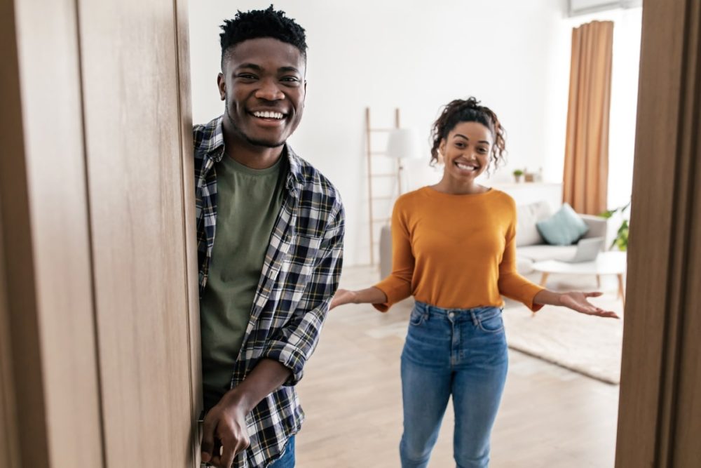 10 Essential Qualities of a Good Tenant: A Comprehensive Guide 6 A welcoming couple opening their front door, showcasing the accessibility and cooperation that landlords value when looking for a good tenant.