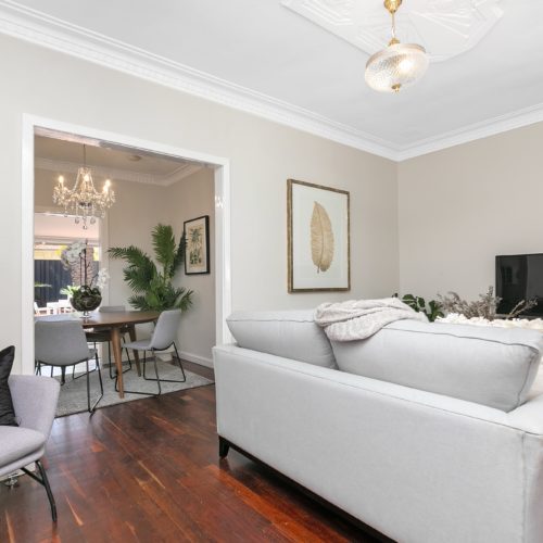 Living area with floorboards and light grey furnishings.